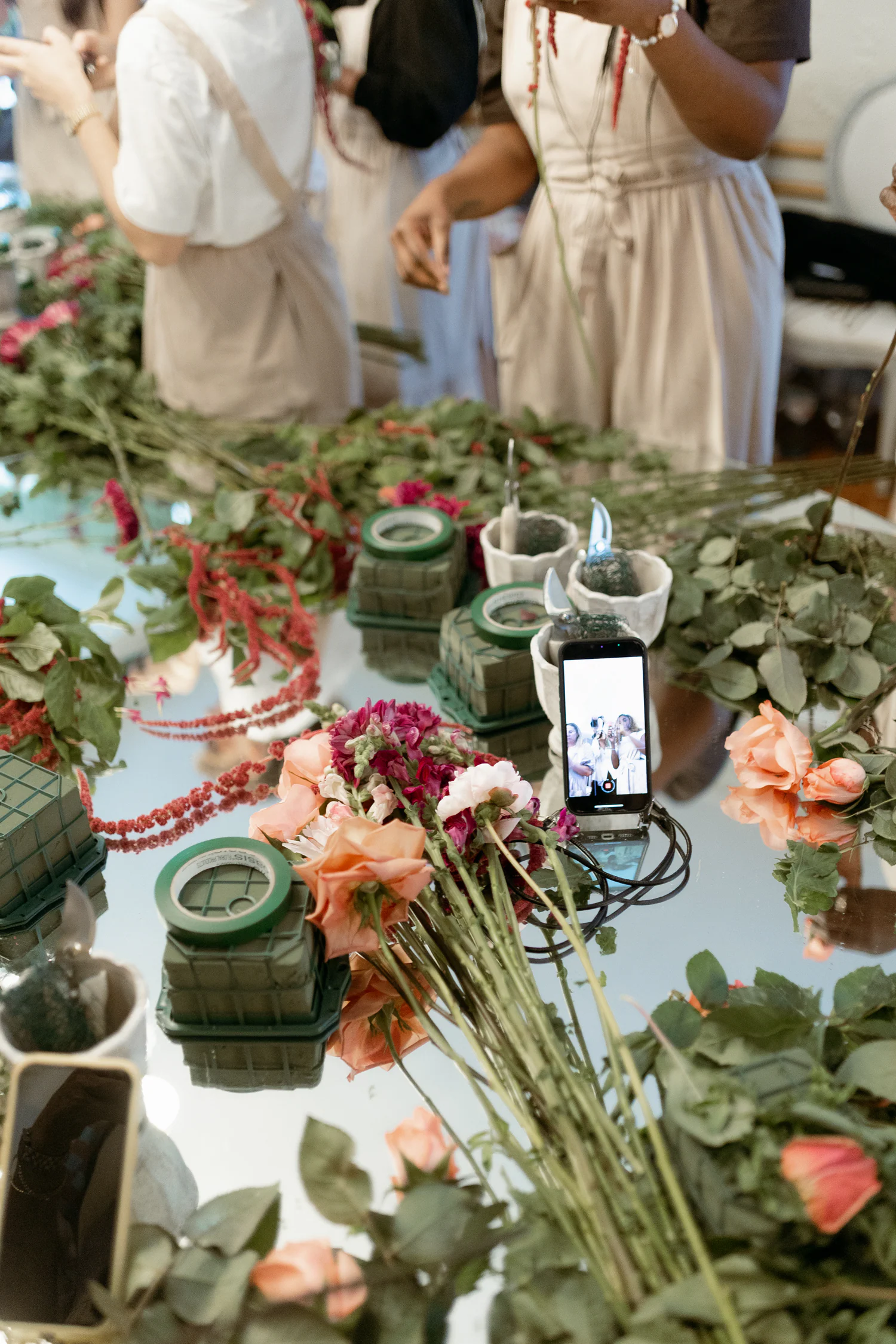 Mesa de workshop com flores, ferramentas e recipientes