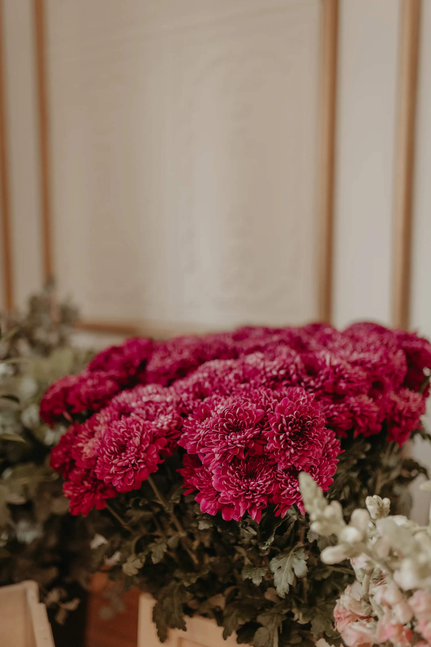 Flores cor de ameixa junto a uma mesa de evento