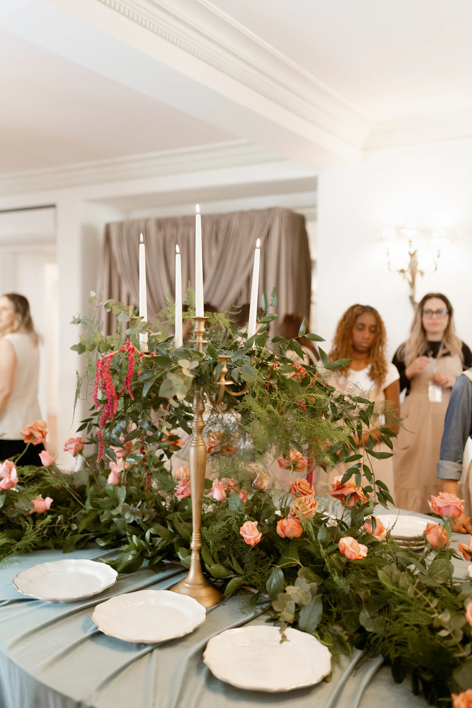 Convidadas junto a uma instalação floral de mesa