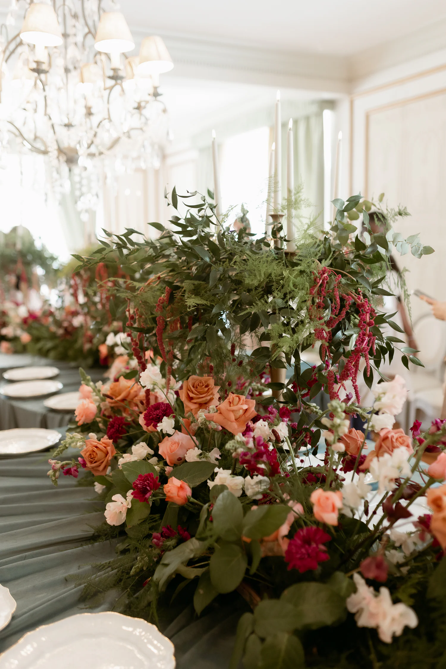 Instalação floral abundante sobre uma mesa comprida