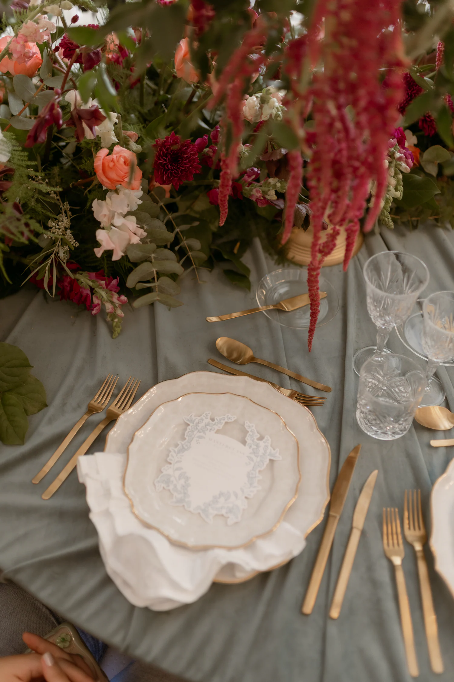 Lugar de mesa com loiça branca, linho e flores profundas