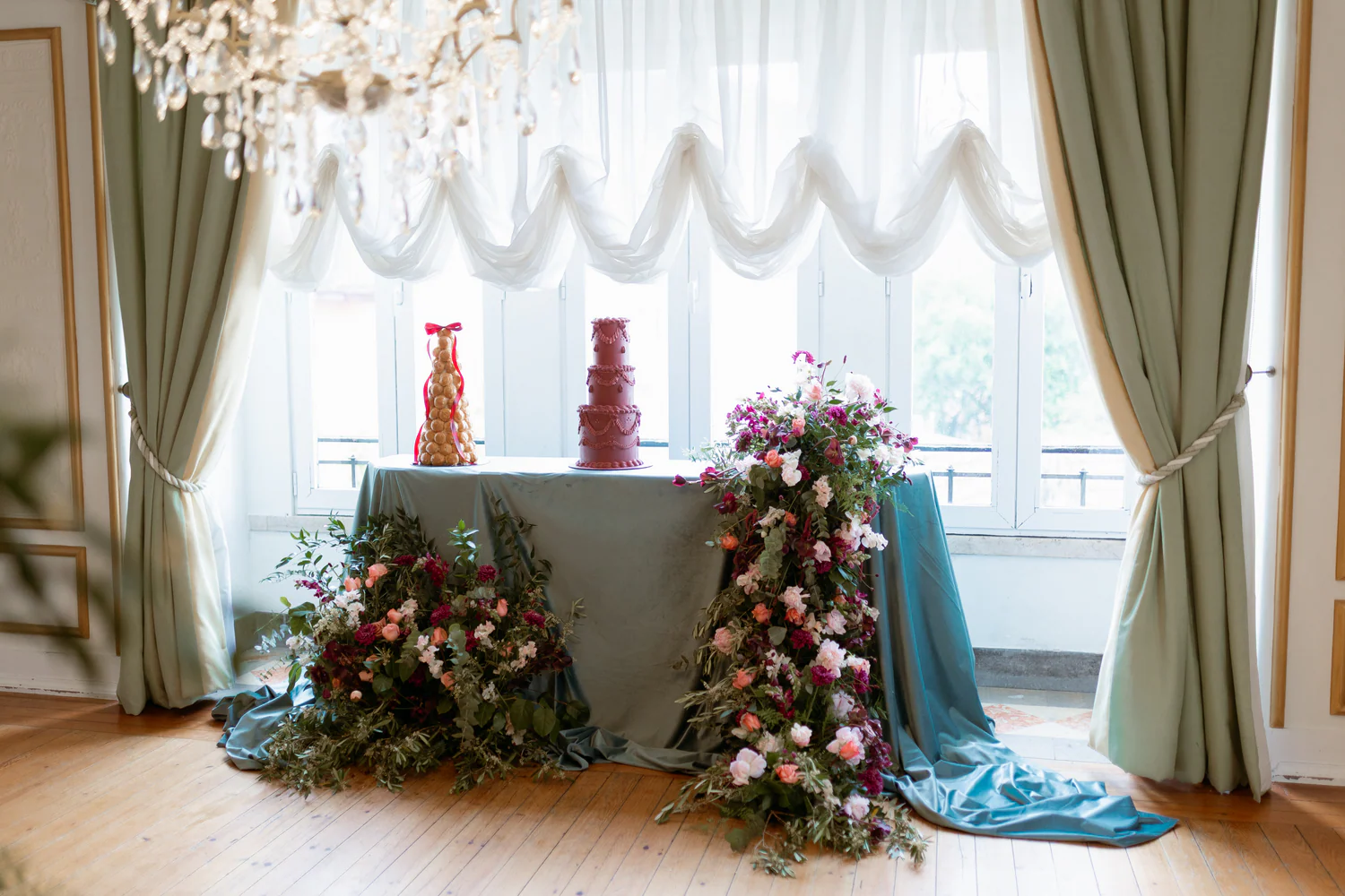 Mesa de celebração com bolos e arranjos florais